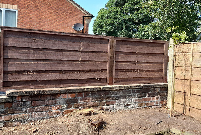 Fencing with bolt down post plates on a small wall