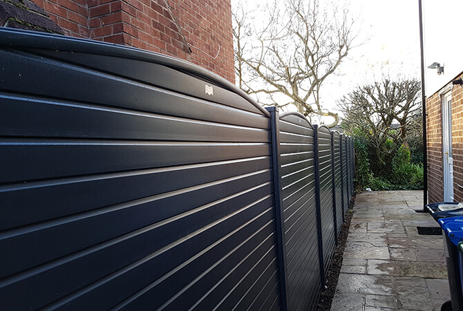 Anthracite grey woodgrain wrapped fencing with a bowed top