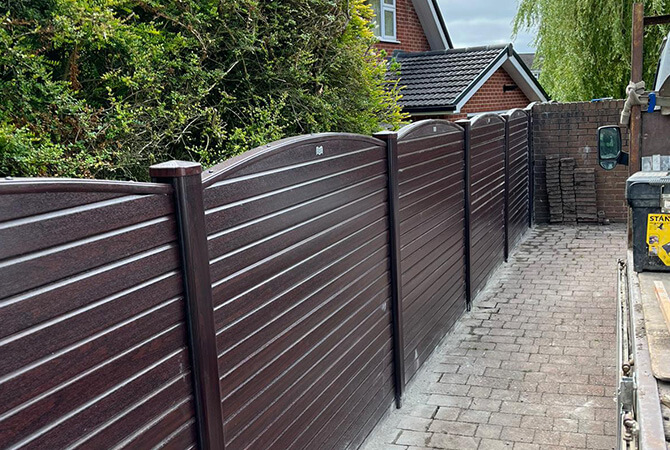Rosewood woodgrain wrapped fencing with a bowed top