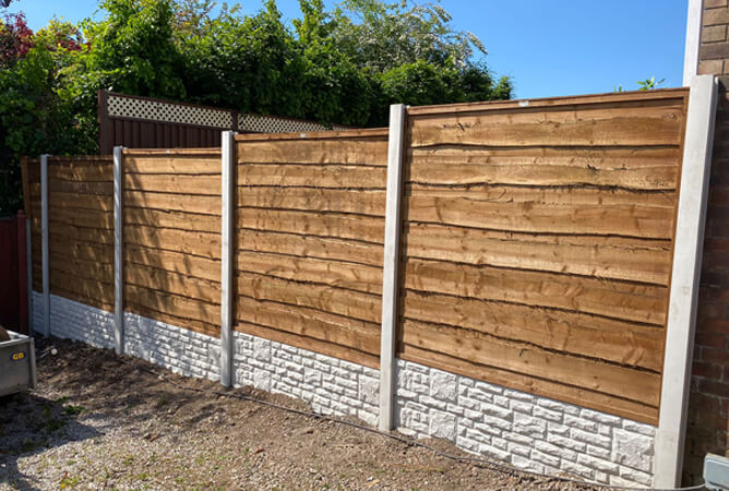 Heavy duty waney lap fencing treated in golden brown