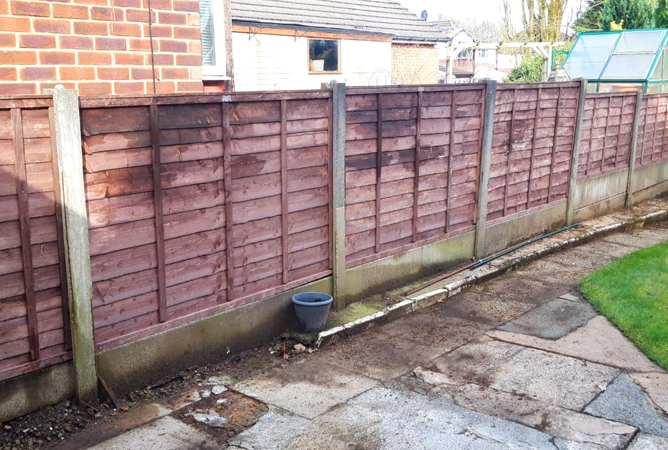 Overlap Waney fence panels slotted into concrete fence posts