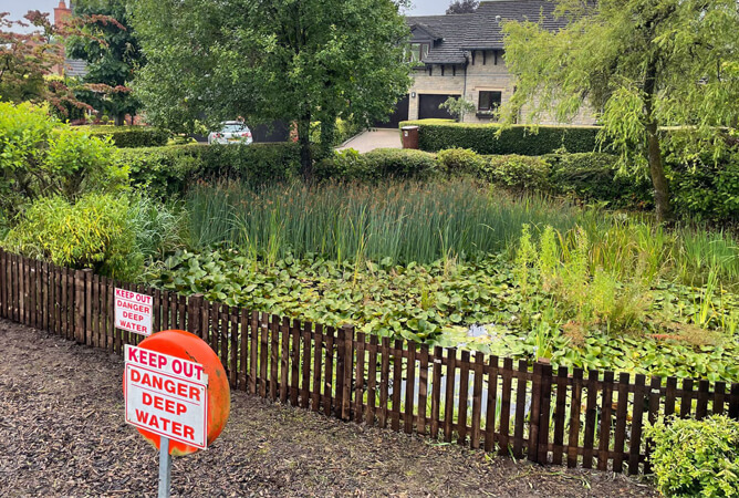 Low level picket fencing around the pond in Edgworth