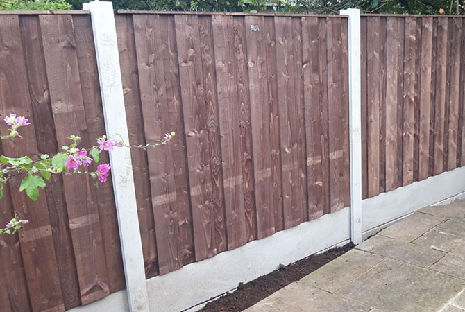 vertical lap fence panels in new concrete posts and bases