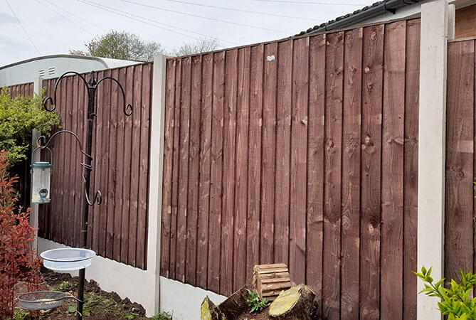 vertical lap fence panels in new concrete posts and bases