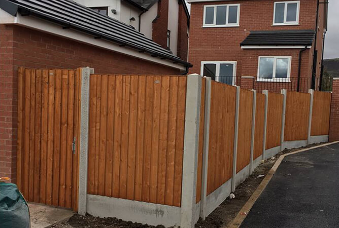 Orange vertical lap fence panels, concrete posts and bases