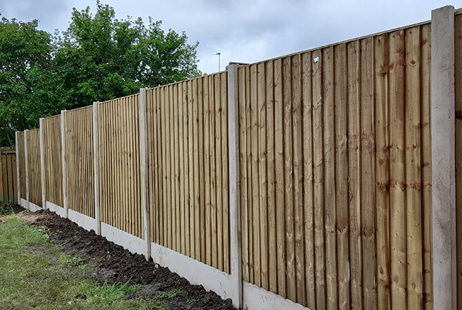 Pressure treated vertical lap fence panels with concrete posts and bases