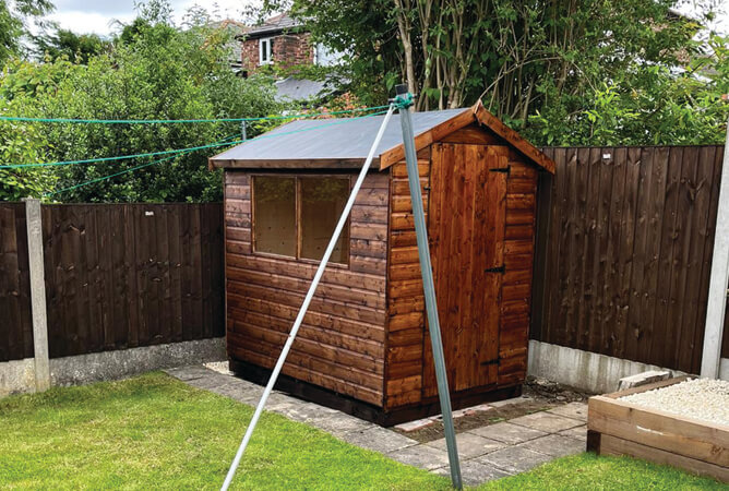 Norfolk shed treated in dark brown with a rubber roof