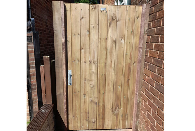Tongue and groove garden gate with dark brown treatment