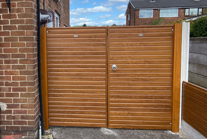 Double set of golden oak woodgrain wrapped UPVC gates